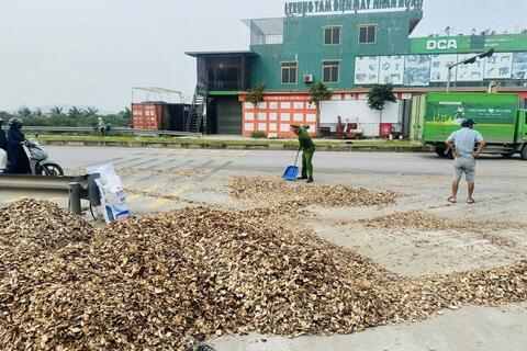 Cán bộ Công an giúp Nhân dân thu dọn gỗ dăm bị đổ trên đường