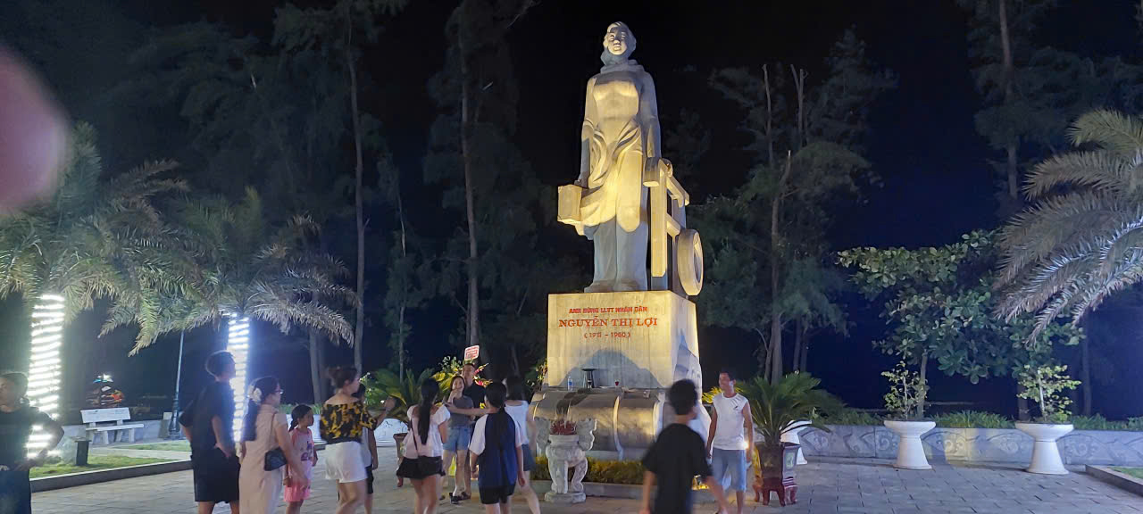 du khách tham quan, chụp hình bên tượng đài